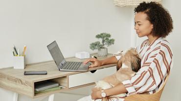 Vrouw werkt achter laptop en maakt gebruik van flexibel werkenmogelijkheden door op afstand te werken vanuit haar thuiskantoor.